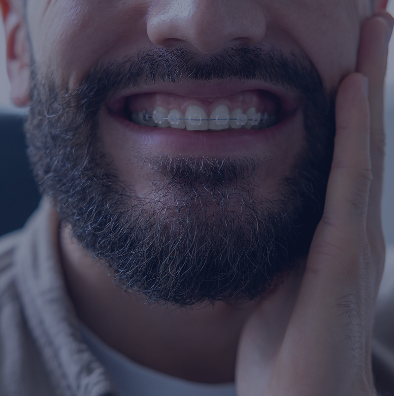 Man smiling with hand on cheek