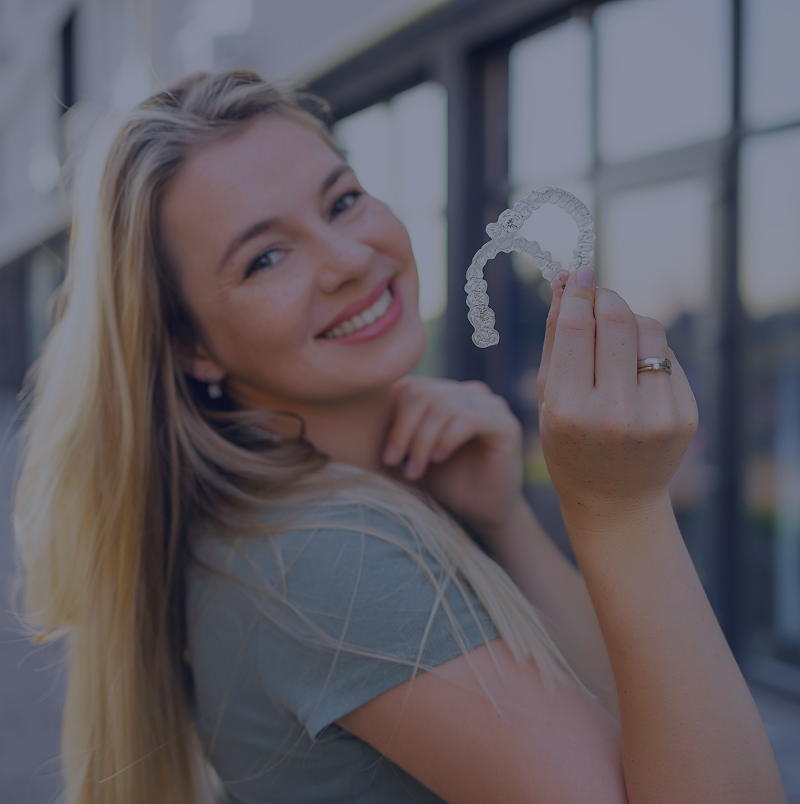 Happy person showing invisible braces outdoors