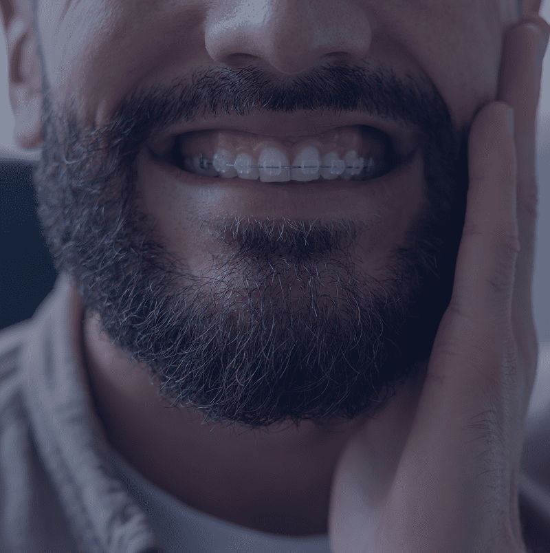 Man smiling with hand on cheek