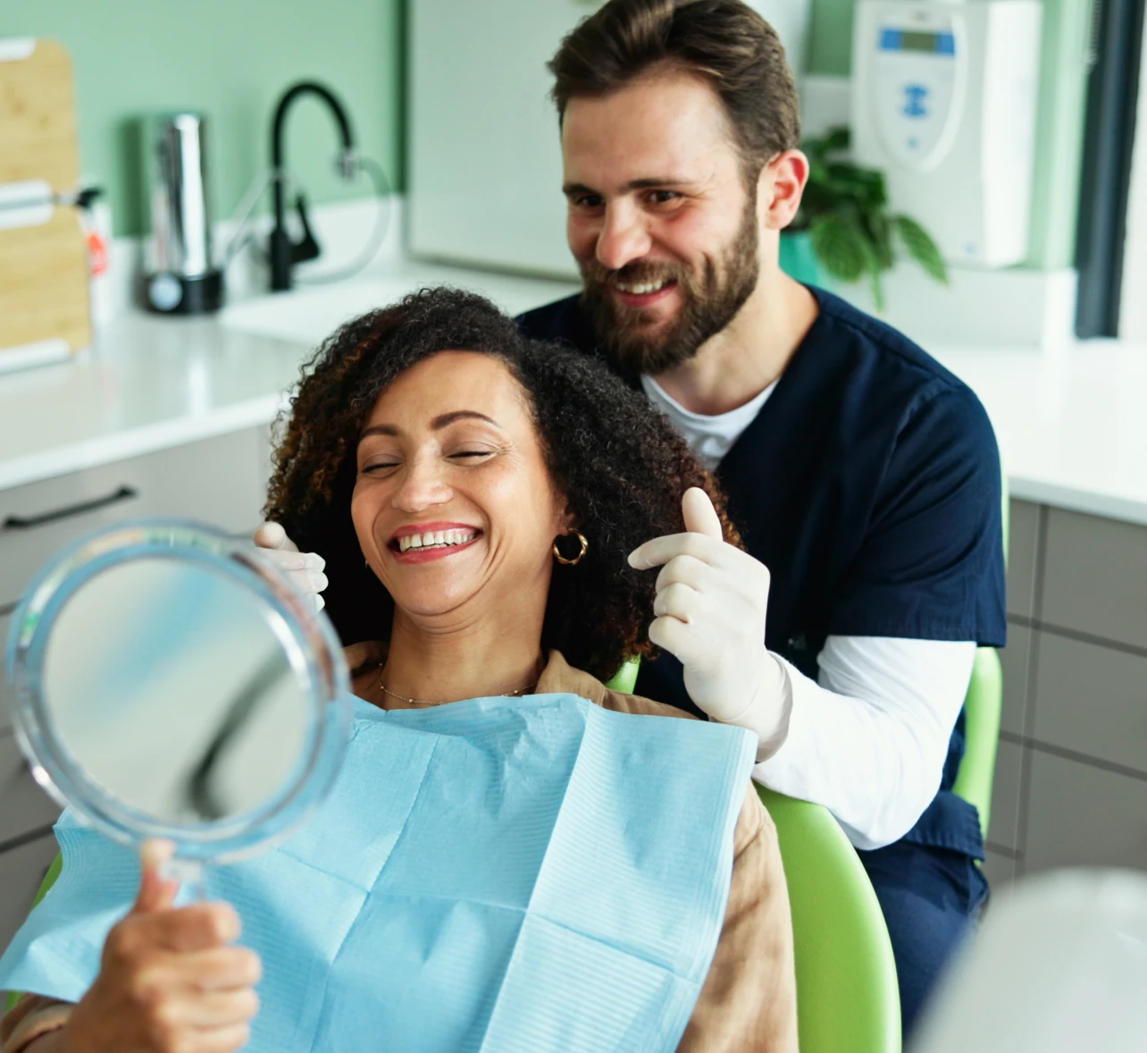 Dentist and patient smiling together