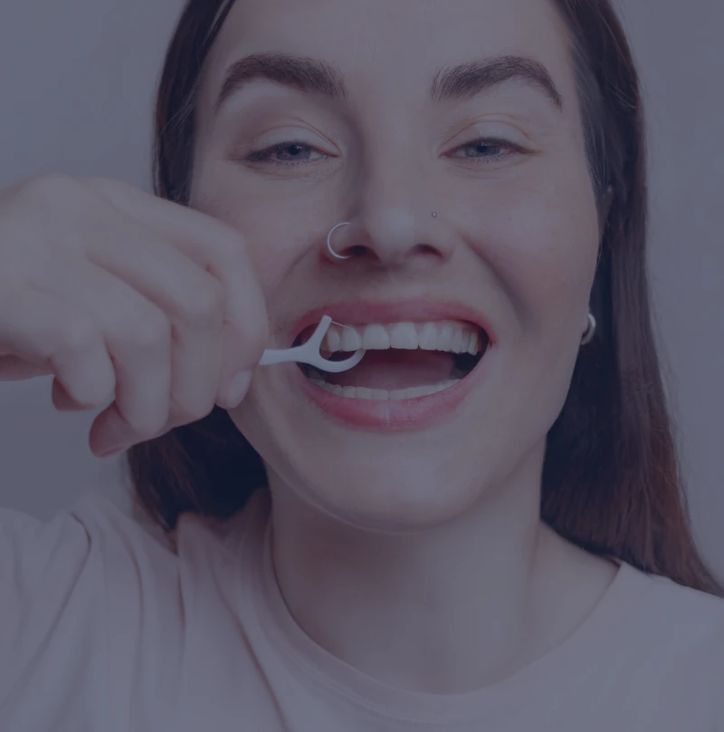 Woman using dental floss pick