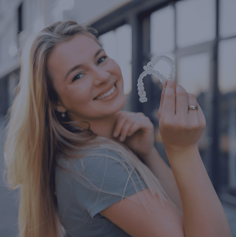 Happy person showing invisible braces outdoors